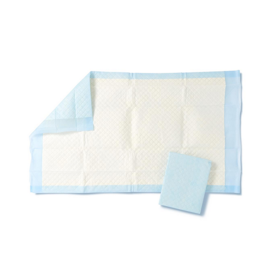 The Medline Disposable Fluff and Polymer Underpads, a white rectangular pad with a light blue border, is partially folded to demonstrate its heavy absorbency. Another underpad, designed for moisture protection, sits next to it.